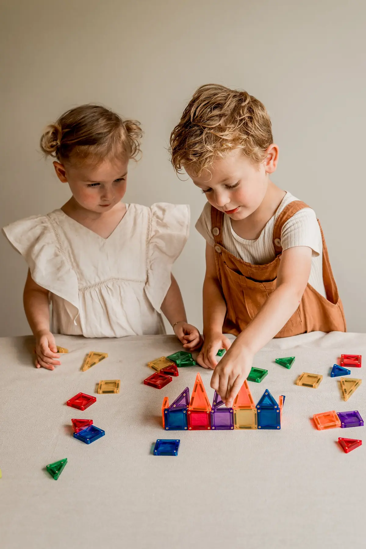 Twee peuters bouwen aan tafel met micro-tegels
