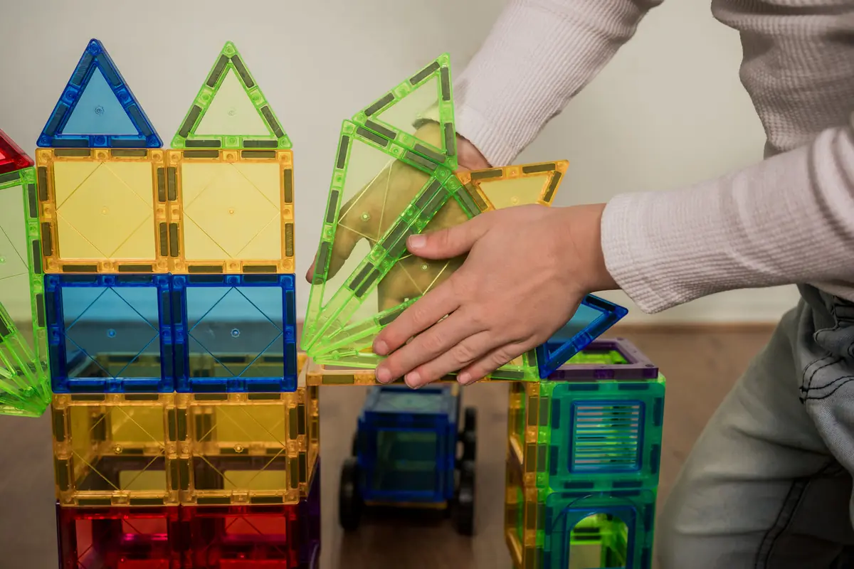 Kind en ouder bouwen samen een huis van magnetische tegels